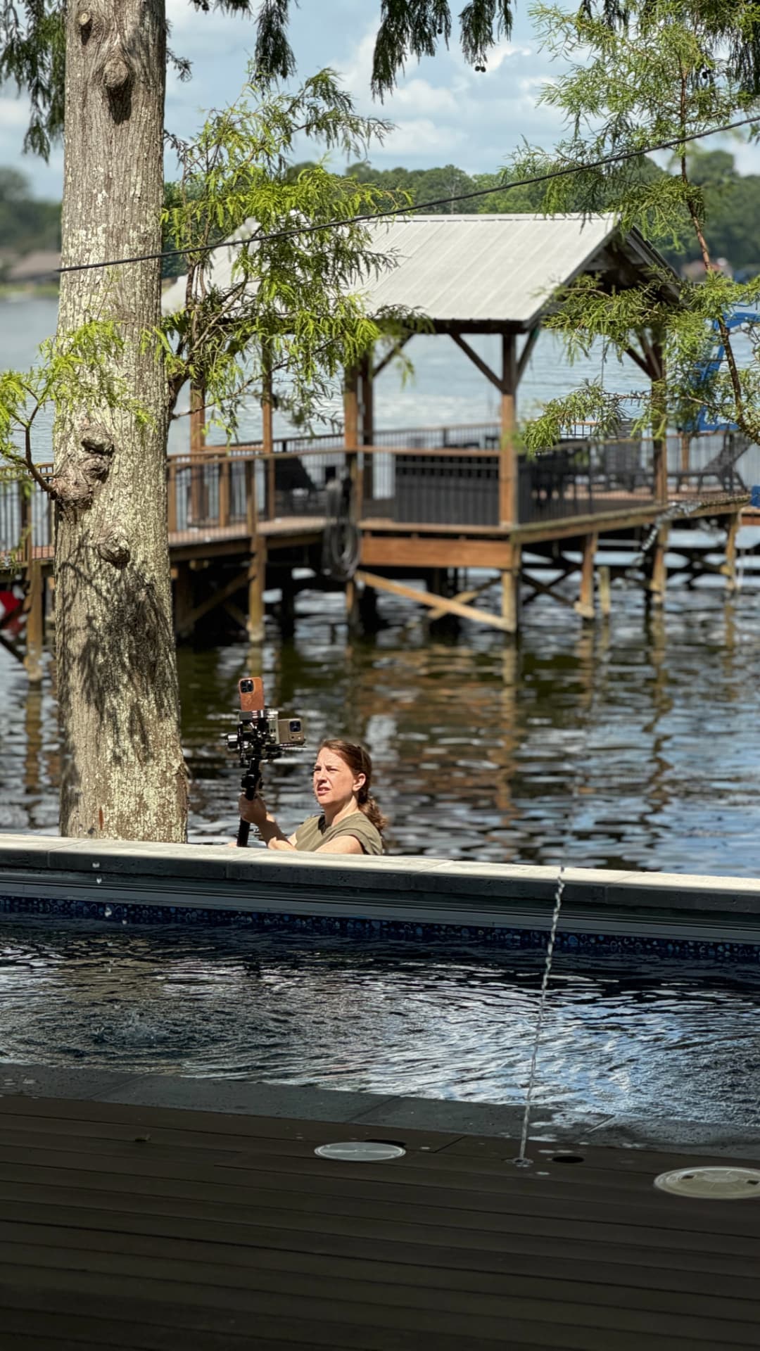Lindy filming a lakeside custom home from the pool deck