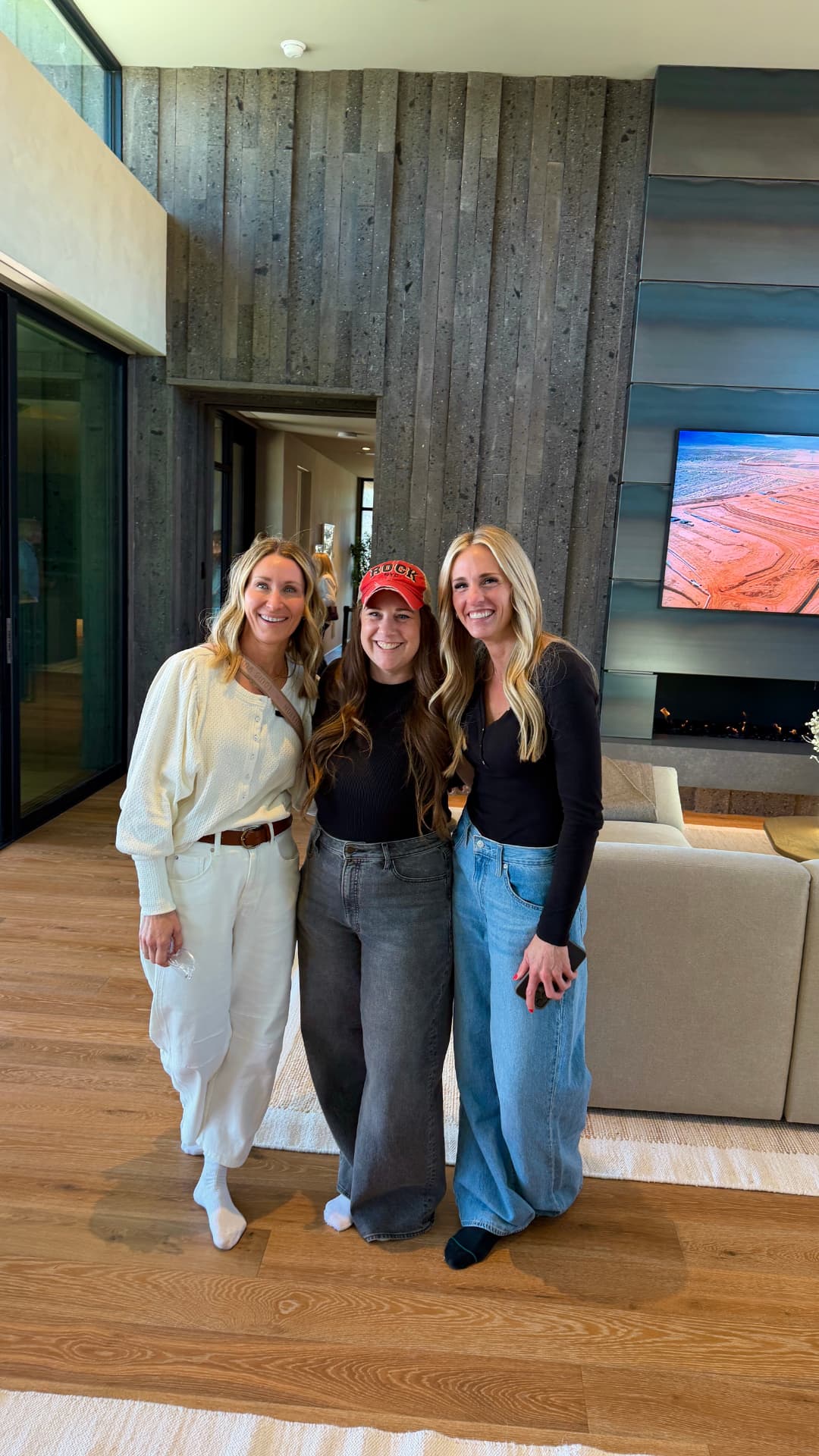 Lindy with two designers in front of a board-formed concrete fireplace